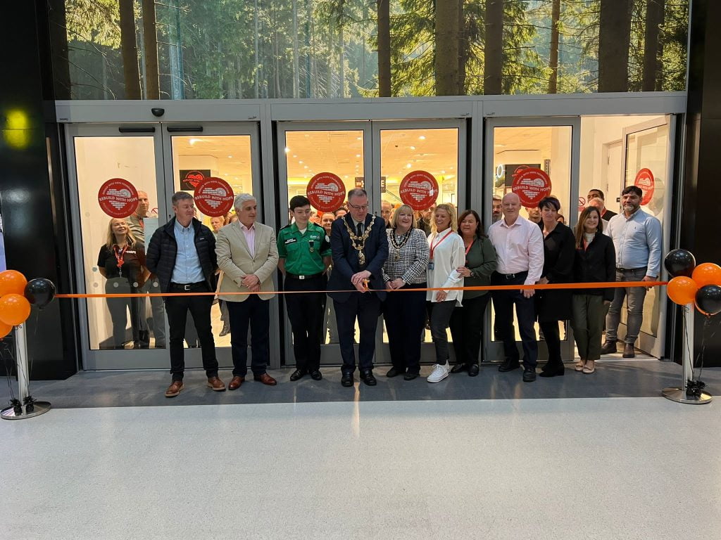 The Mayor of Wigan and a crowd of guests cutting an orange ribbon at the entrance to the new social enterprise hub
