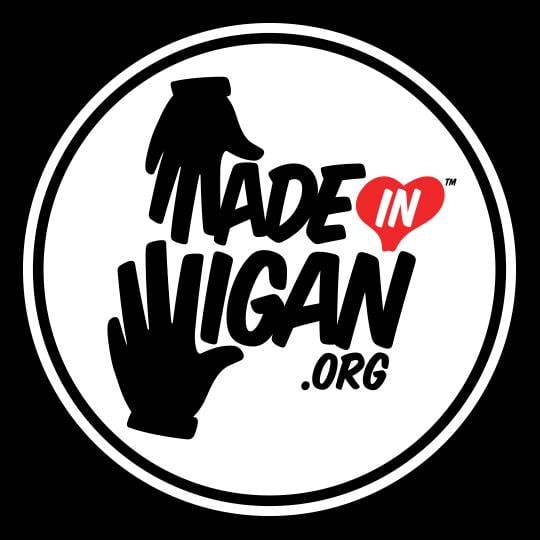 The Made in Wigan logo: a black circle enclosing a hand print, the words 'Made in Wigan' and a red heart