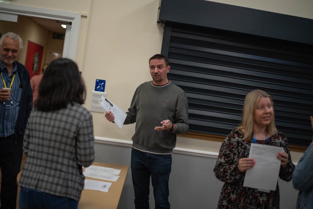 Guests talking and handing out papers at the Proper Good Wigan Borough launch event