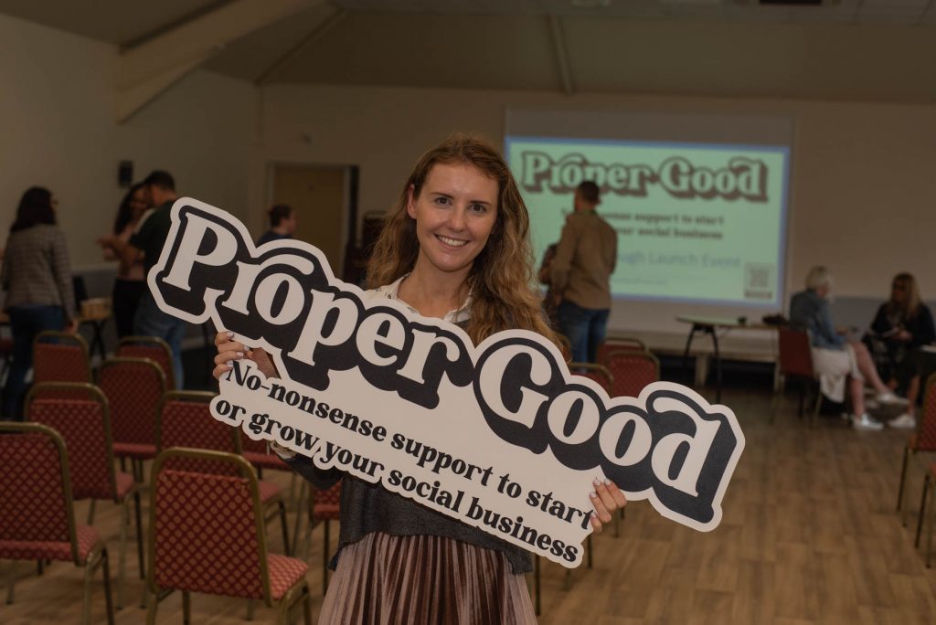 A guest holding the Proper Good sign in the launch event hall