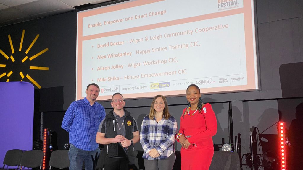 Four panellists on stage at the Believe in Business Festival for the session 'Enable, Empower and Enact Change'